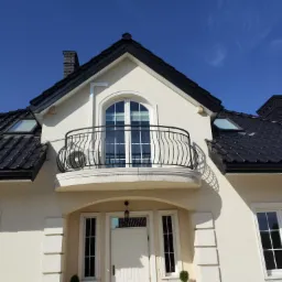 Elewacja domu jednorodzinnego z balkonem, na którym zamontowano zewnętrzną jednostkę klimatyzatora Hyundai.