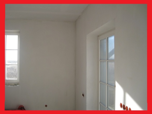 Świeżo otynkowane, gładkie ściany w jasnym pomieszczeniu z oknem i drzwiami w Obornikach Śląskich, gotowe do malowania lub dalszego wykończenia.