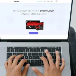 Osoba pisze na laptopie, na ekranie widoczna strona internetowa rozwojomat.pl z kursem online o zmianie myślenia i podwojeniu dochodów.