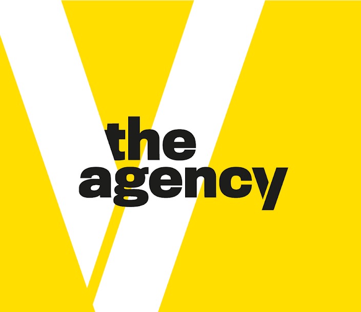 Graficzne logo agencji marketingowej: czarny napis 'the agency' na żółtym tle z białymi ukośnymi paskami tworzącymi literę V.