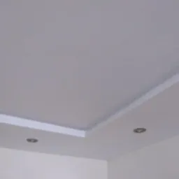 Szpachlowana i pomalowana na biało sufit z zamontowanymi dwoma punktowymi lampami LED i dekoracyjną listwą przysufitową.