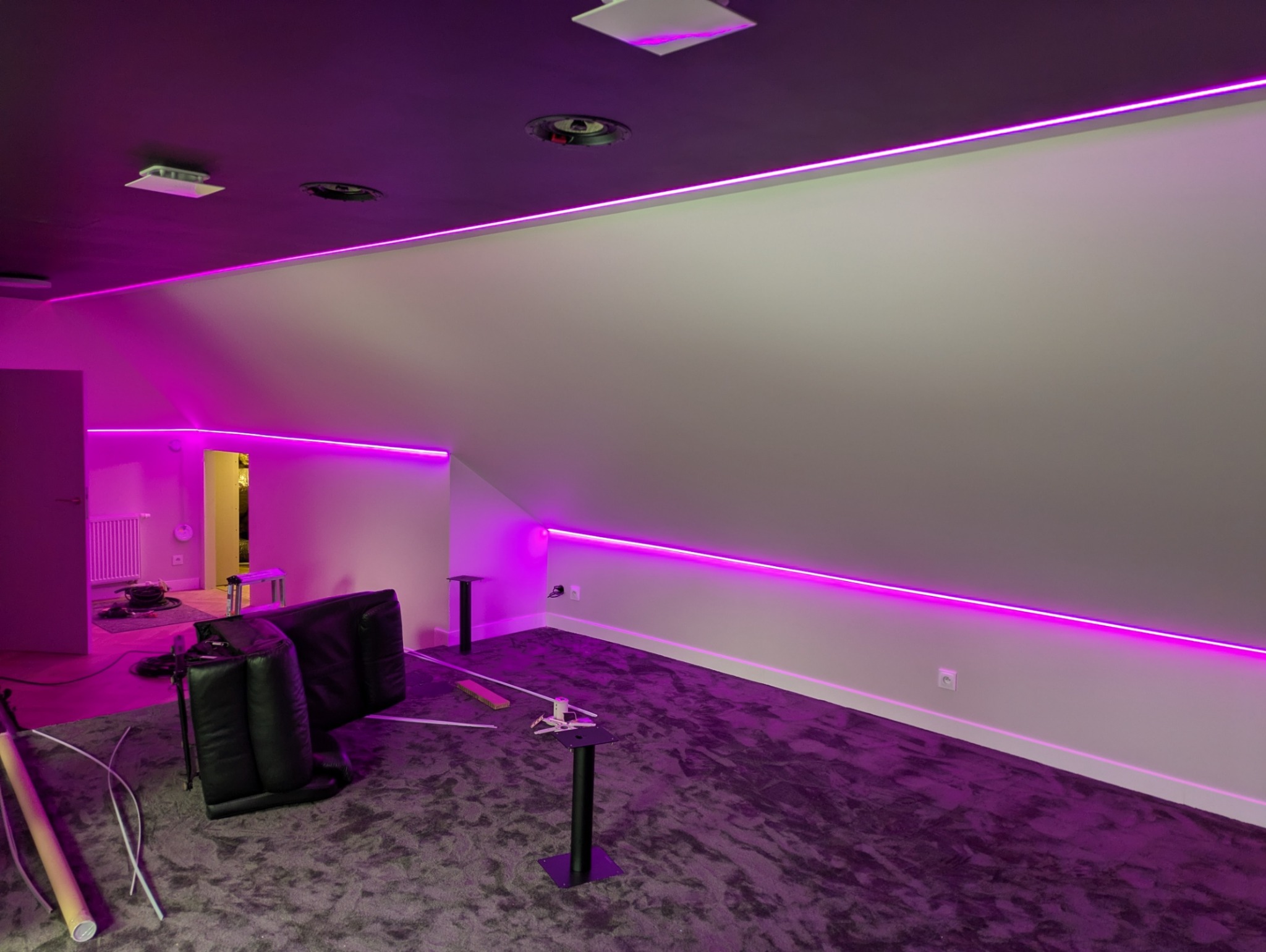 Podświetlenie LED RGB w pokoju na poddaszu, z widocznymi elementami instalacji i meblami w trakcie montażu. Fioletowe światło podkreśla nowoczesny charakter wnętrza.