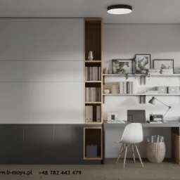 Nowoczesne biuro domowe z minimalistycznym biurkiem, białym krzesłem, półkami z książkami i szarą zabudową meblową z elementami drewna.