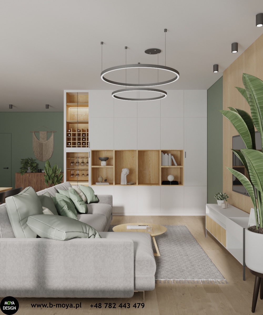 Nowoczesny salon z szarą sofą, okrągłym stolikiem kawowym i zabudową meblową z podświetlaną wnęką na wino, oświetlony wiszącymi lampami pierścieniowymi.