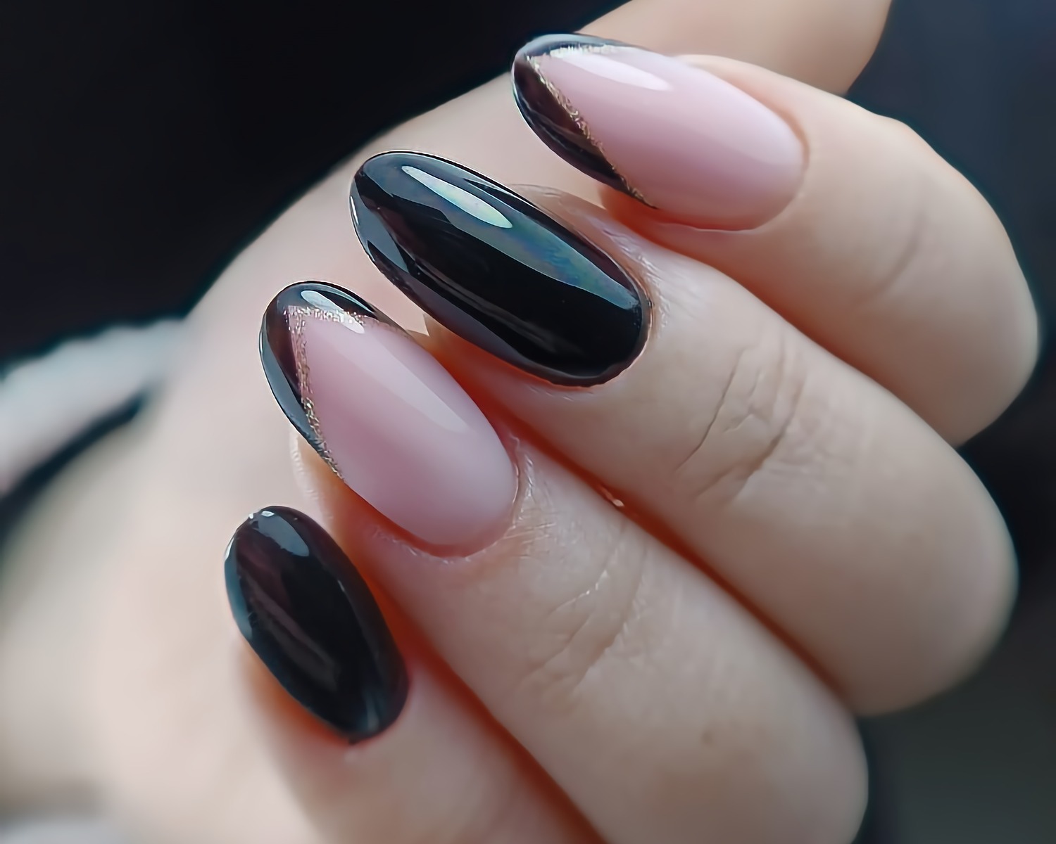 Eleganckie paznokcie: połączenie czarnego lakieru z efektem lustra i jasnoróżowego french manicure z delikatnym złotym akcentem.