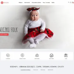 Strona internetowa sklepu Besemi.pl z ofertą spódniczek folk dla dziewczynek, prezentowana na zdjęciu niemowlę ubrane w białe body, czerwoną spódniczkę z folkowym wzorem i białą opaskę z kokardą.