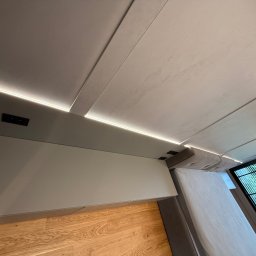 MSMeble (ZAKS) - Nowoczesna sypialnia: drewniana podłoga, szara ściana z listwą LED, łóżko i okno z widokiem na zieleń. Minimalistyczny design.