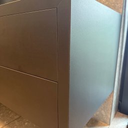 MSMeble (ZAKS) - Nowoczesna, grafitowa szafka łazienkowa z dwiema szufladami, zintegrowana z umywalką i baterią, na tle beżowych płytek. Minimalistyczny design.