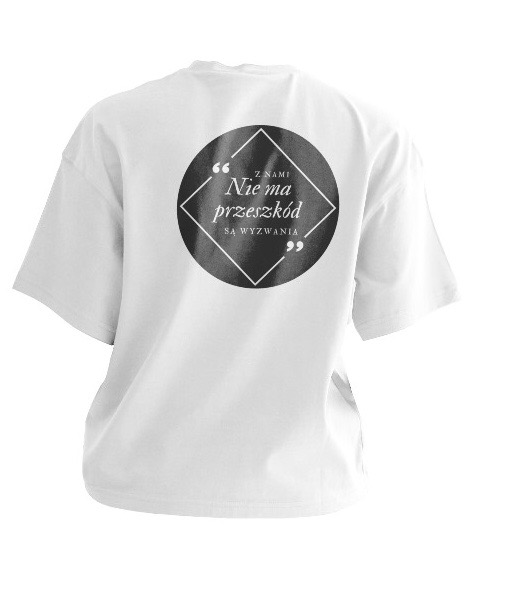 Biała koszulka z nadrukiem na plecach: czarny okrąg z białym rombem, wewnątrz napis 'Z nami Nie ma przeszkód Są wyzwania' w cudzysłowach.