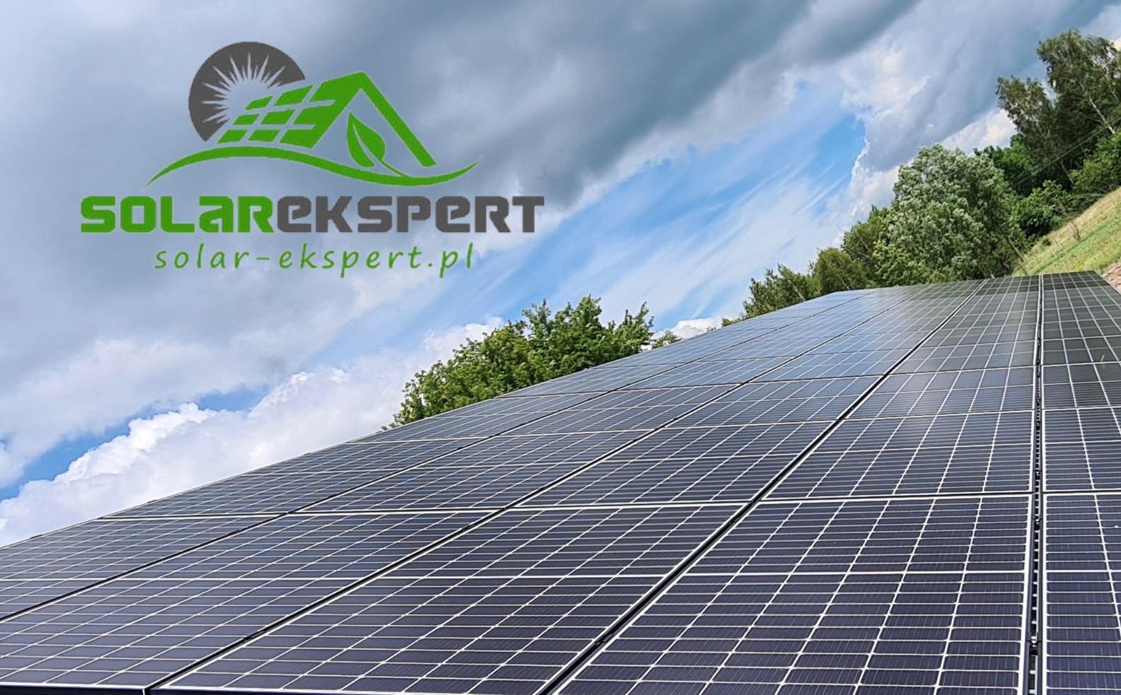Panel słoneczny na dachu z logiem SolarEkspert na tle błękitnego nieba z chmurami.