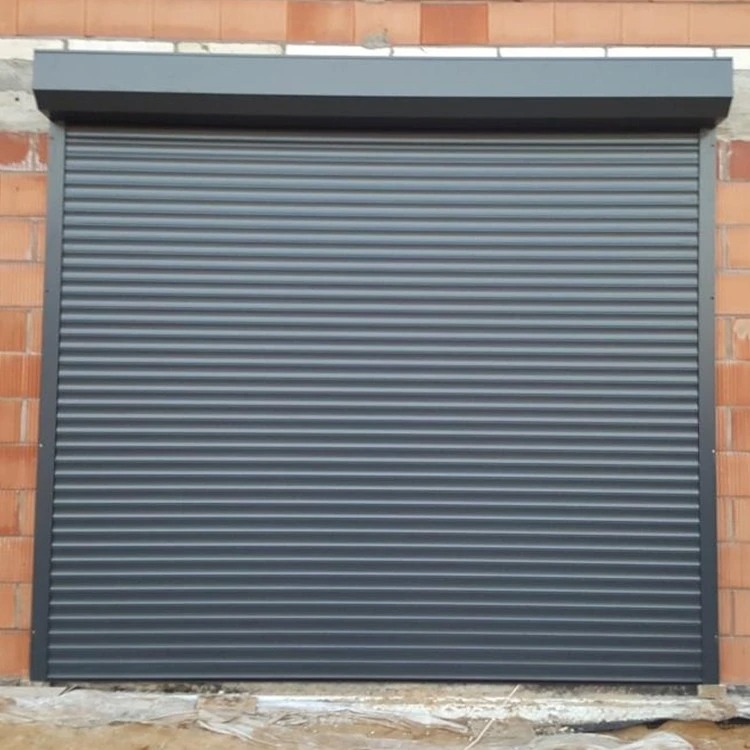 Szara brama rolowana w murze z cegły, widok z przodu, zamknięta. Detal: widoczne poziome lamele i prowadnice boczne.