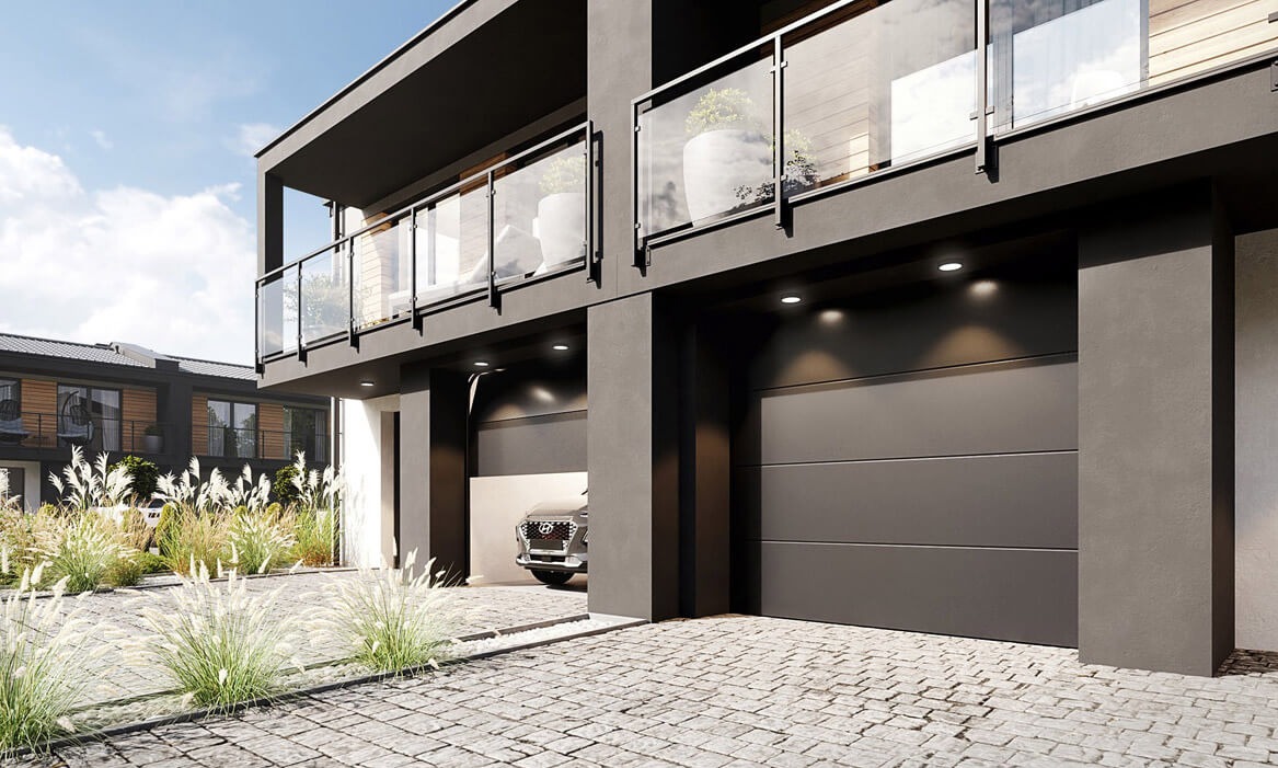 Nowoczesna, grafitowa brama garażowa segmentowa z oświetleniem punktowym, wkomponowana w architekturę dwukondygnacyjnego domu z balkonami i szklanymi balustradami.
