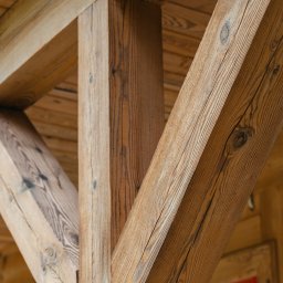 Łukasz Drężewski - Drewniana konstrukcja nośna z widocznymi słojami drewna, po zabiegu renowacji w Garwolinie. Element architektoniczny z bliska, ukazujący detale wykończenia.