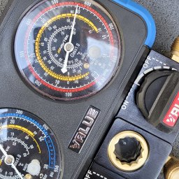 SOFTLIGHT Fotowoltaika & Klimatyzacja - Manometr serwisowy do klimatyzacji z dwoma tarczami, wskazującymi ciśnienie i temperaturę czynnika chłodniczego, z widocznymi zaworami regulacyjnymi i logo 'VALUE'.