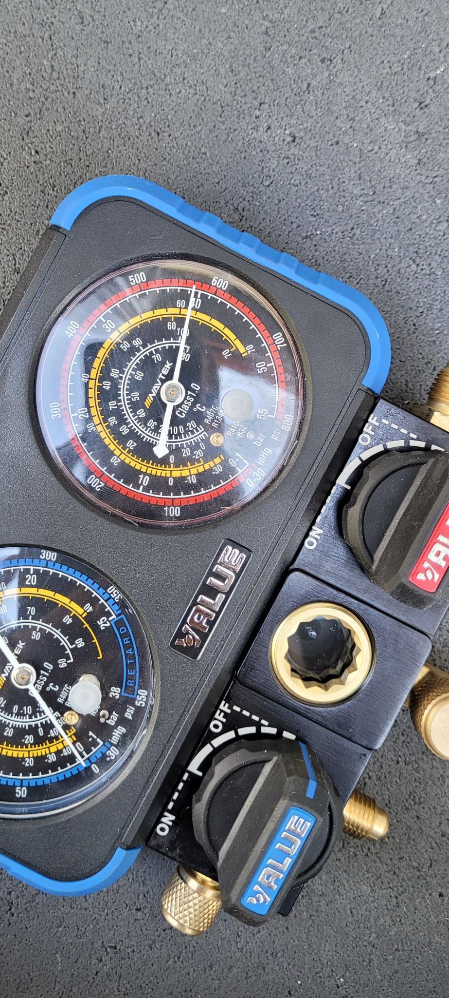 Manometr serwisowy do klimatyzacji z dwoma tarczami, wskazującymi ciśnienie i temperaturę czynnika chłodniczego, z widocznymi zaworami regulacyjnymi i logo 'VALUE'.