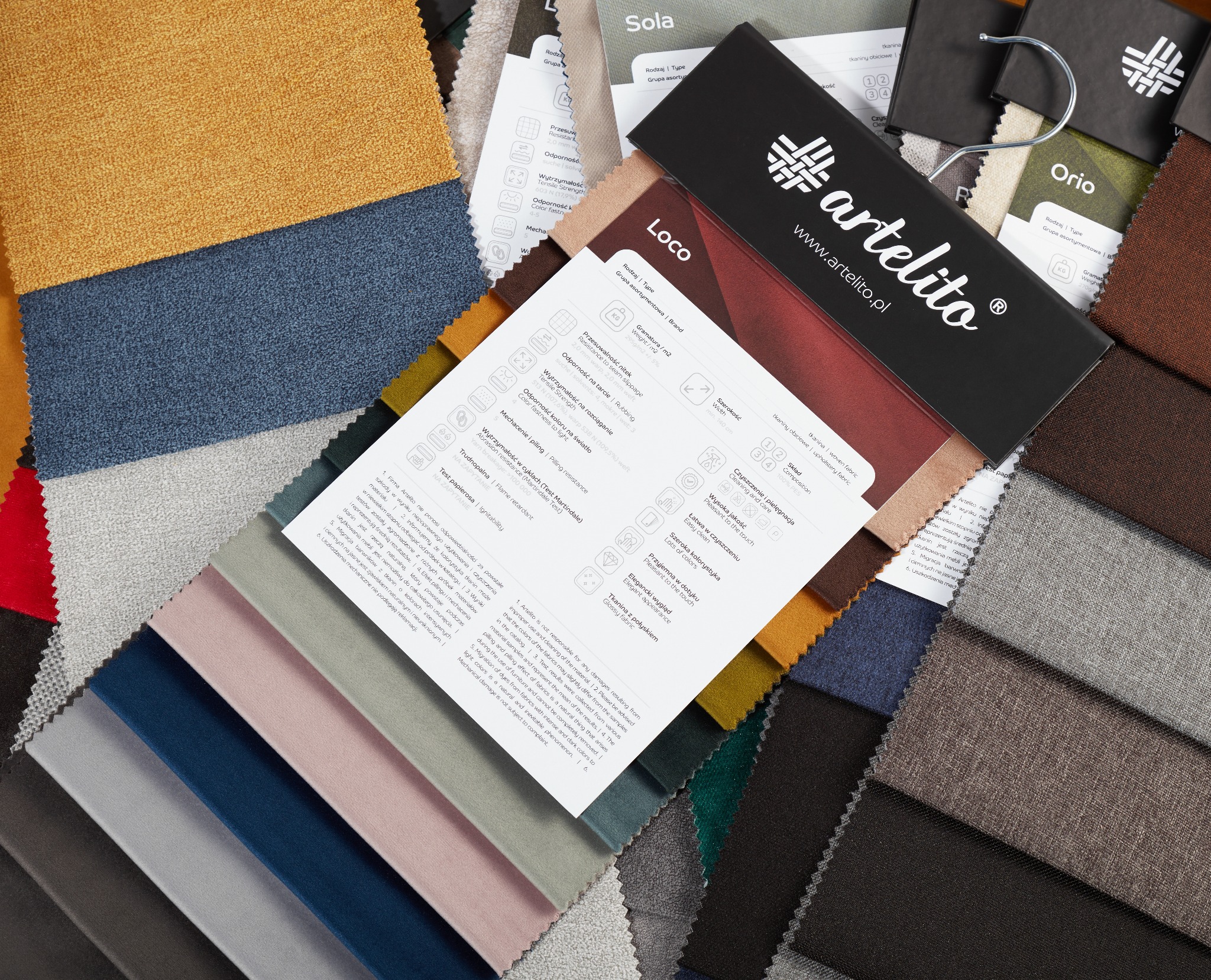 Przekrój próbek tkanin obiciowych w różnych kolorach i fakturach, z etykietami i informacjami o właściwościach, prezentowanych na czarnym tle z logo Artelito.