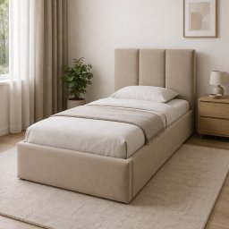 GUTEK MEBLE - Beżowe, tapicerowane łóżko jednoosobowe z zagłówkiem w minimalistycznej sypialni. Obok szafka nocna i lampka. Naturalne światło z okna, dywan w odcieniach beżu.
