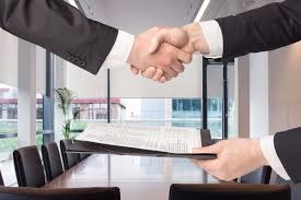 Uścisk dłoni nad dokumentami w eleganckim biurze, symbolizujący zawarcie umowy.