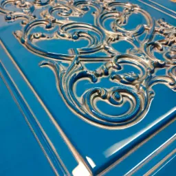 Błękitny front drzwi z ozdobnymi, srebrnymi ornamentami w stylu barokowym, widoczne z perspektywy.