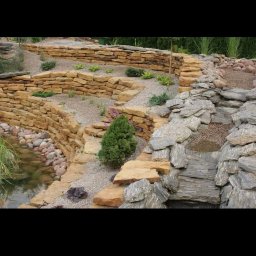 Visual Garden - Kaskadowy ogród skalny z elementami wodnymi, zbudowany z piaskowca i łupka, z nasadzeniami roślin iglastych i liściastych.