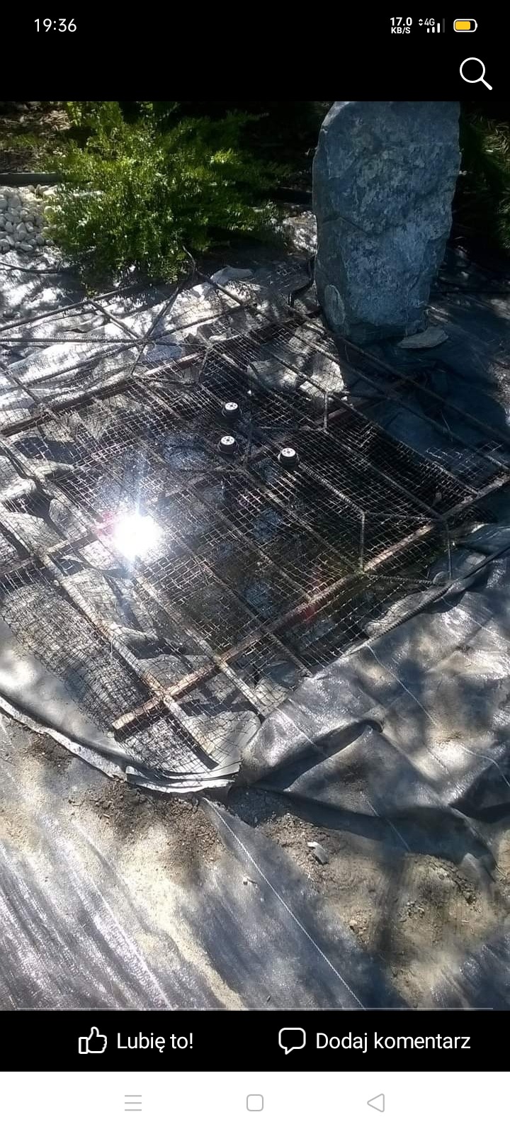 Przygotowanie podłoża pod basen: siatka zbrojeniowa, czarna folia, kamień dekoracyjny w ogrodzie.