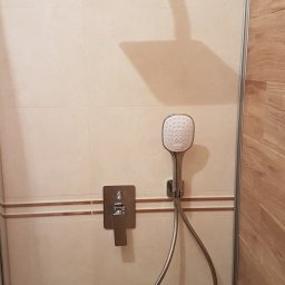 Instal-rem - Nowoczesna kabina prysznicowa z deszczownicą i baterią podtynkową, wykończona beżowymi płytkami i drewnopodobnymi panelami.