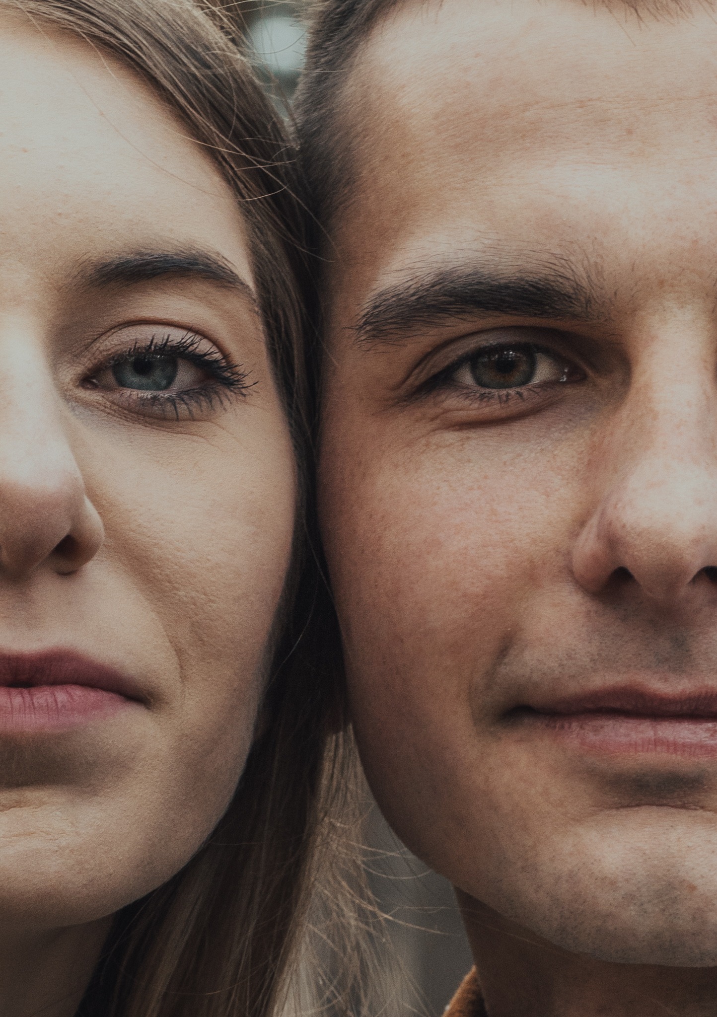Zbliżenie na twarze pary, z widocznymi detalami skóry i oczu, z delikatnym uśmiechem mężczyzny.