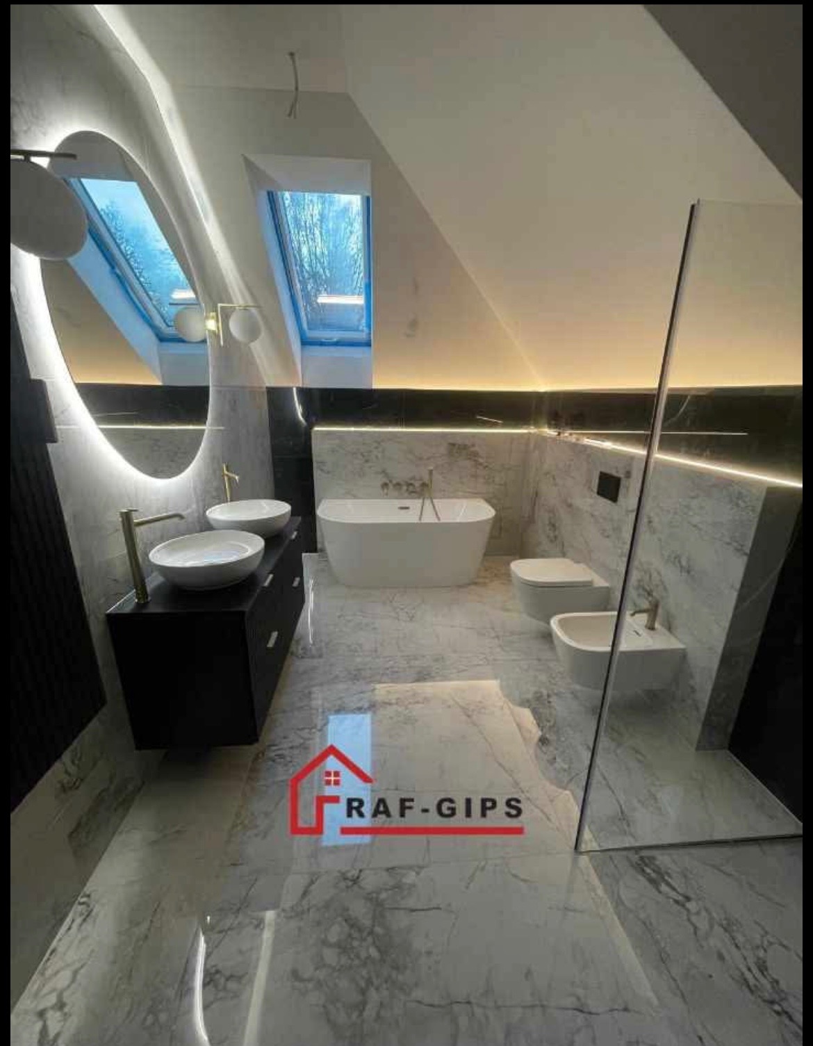 Elegancka łazienka na poddaszu z marmurową posadzką i ścianami, owalnym lustrem z podświetleniem LED, wolnostojącą wanną i oknem dachowym, widok z perspektywy podłogi, logo firmy na posadzce.