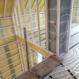 Grudziądz - Wnętrze w trakcie remontu: widoczne ocieplenie poddasza wełną mineralną, drewniana konstrukcja szkieletowa ścian działowych oraz system ogrzewania podłogowego z rurami zamocowanymi do folii...