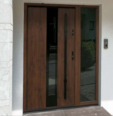 Nowoczesne, brązowe drzwi wejściowe z przeszkleniem po bokach i w pionowym pasie po lewej stronie, z długim, czarnym uchwytem i elektronicznym zamkiem na białej ścianie.