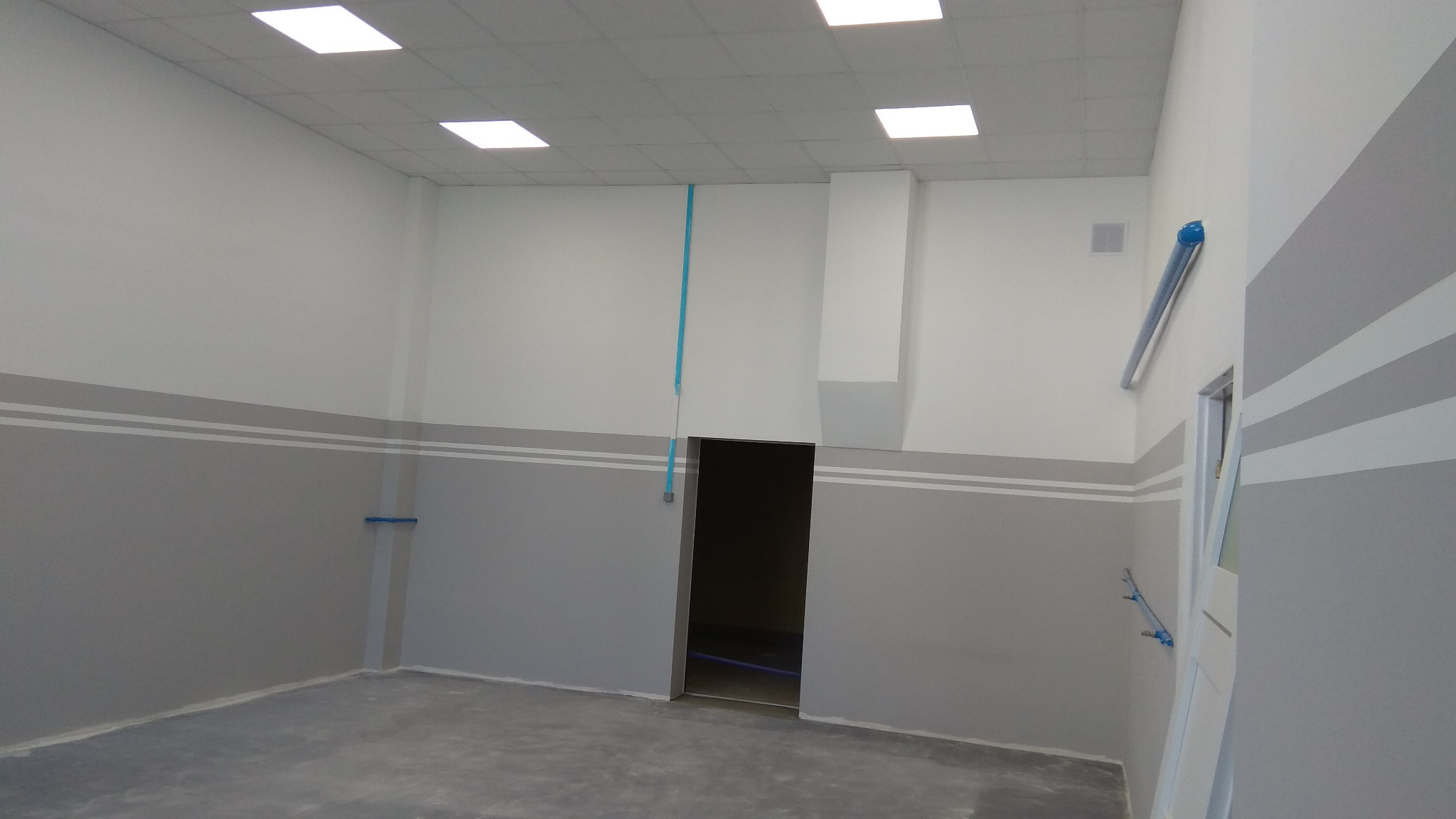 Wnętrze nowo wykończonego pomieszczenia w Łapach z widocznymi przewodami elektrycznymi prowadzonymi po ścianach i suficie, przygotowane pod montaż oświetlenia.