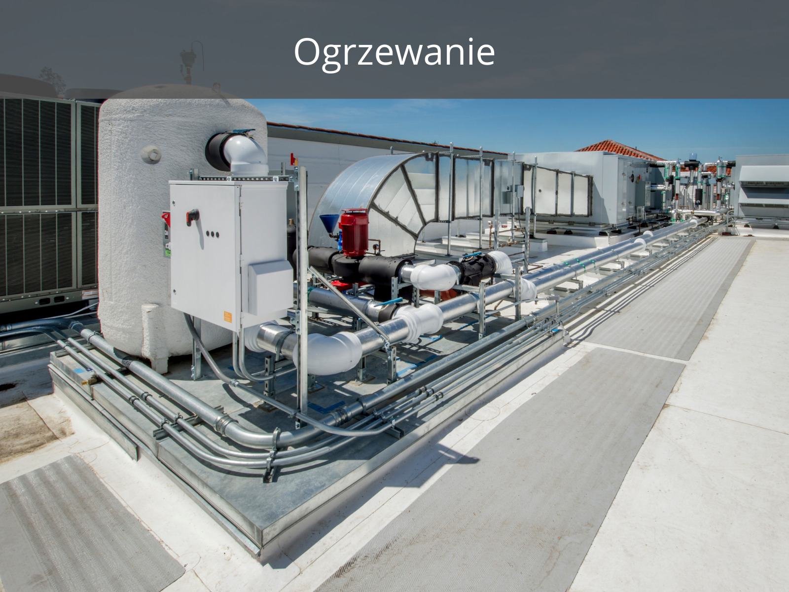 Instalacja wentylacyjna na dachu budynku, widoczne rury, kanały wentylacyjne oraz centrala wentylacyjna z elementami izolacji termicznej i elektrycznymi skrzynkami sterowniczymi. Całość zamontowana...