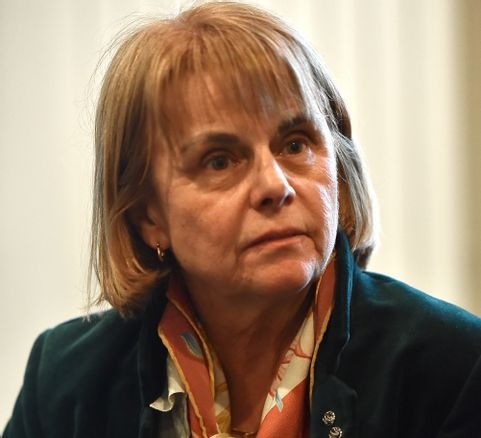 Portret kobiety w zielonej marynarce i wzorzystej apaszce na jasnym tle.