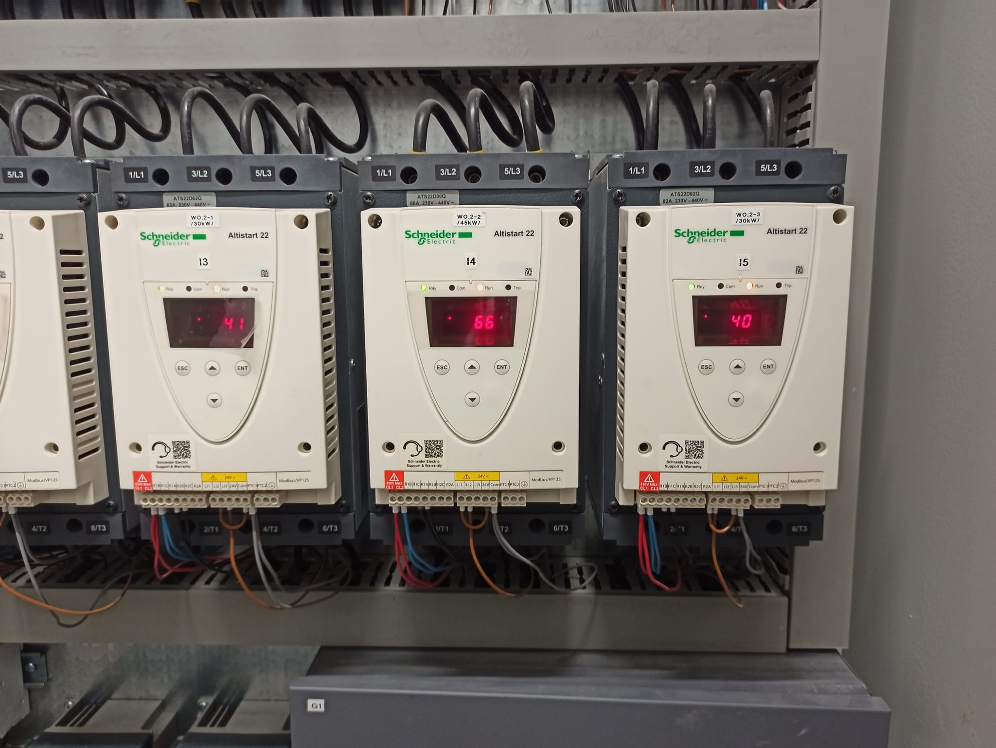 Panel sterowania przemysłowego z trzema modułami Schneider Electric Altistart 22, każdy z wyświetlaczem LED pokazującym różne wartości (41, 66, 40), podłączonymi kablami i oznaczonymi zaciskami.