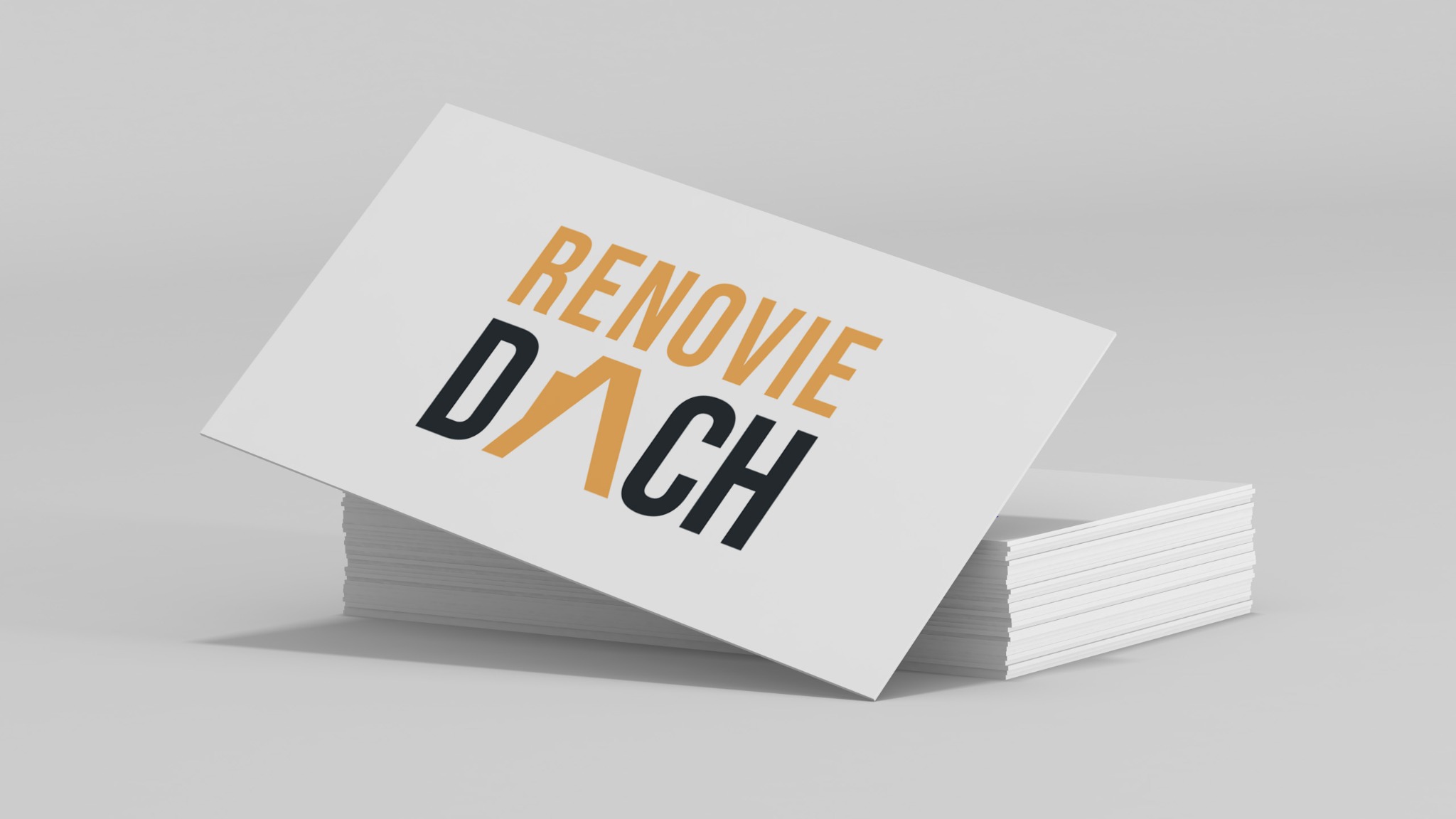 Stos wizytówek z logo 'Renovie Dach' w kolorach pomarańczowym i czarnym, na jasnoszarym tle.