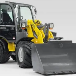 Żółto-szara ładowarka kołowa Wacker Neuson WL37 z szarą łyżką na białym tle, widok z przodu i z lewej strony.