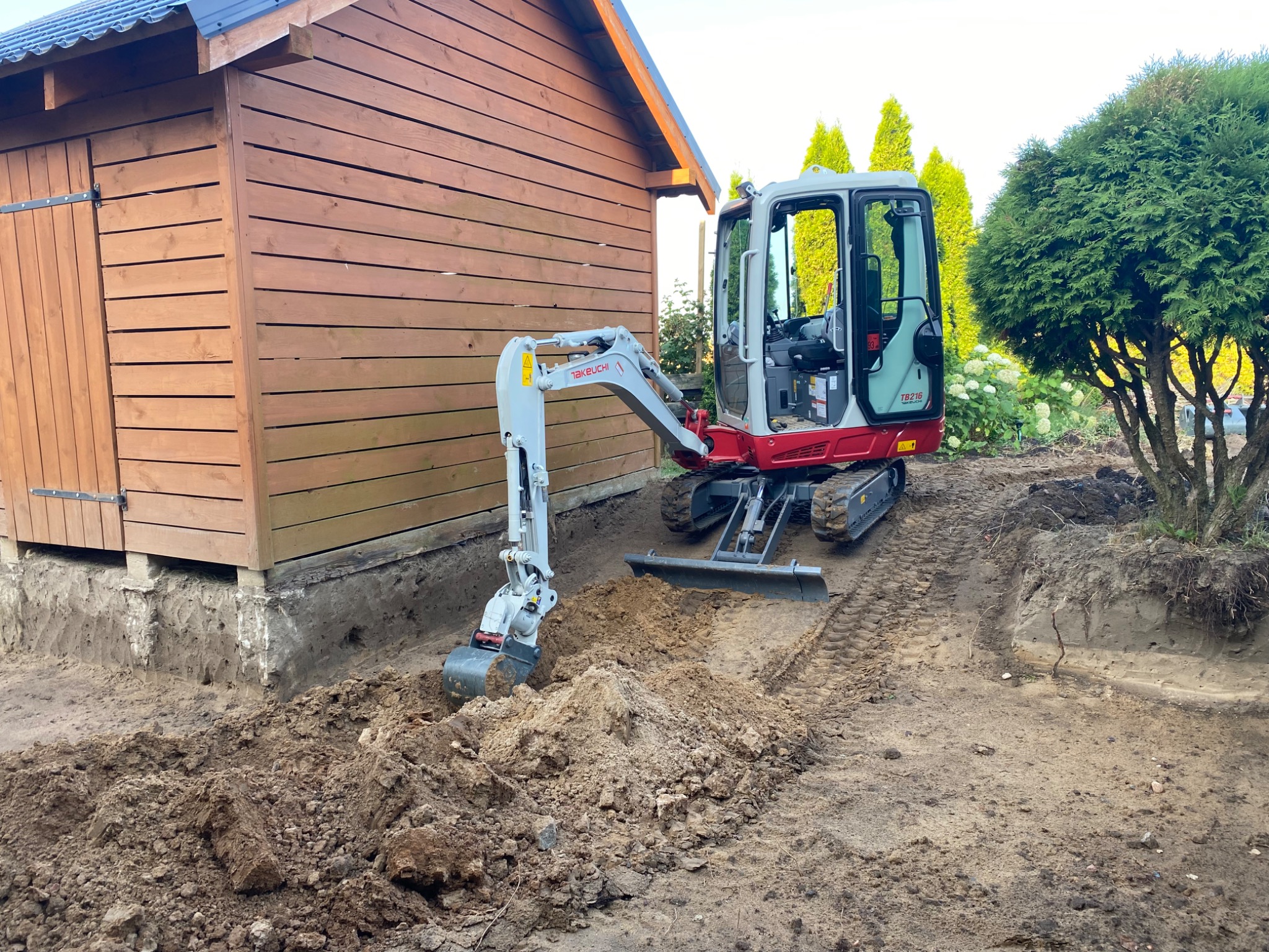 Wykopy pod instalacje nawadniającą z domu na ogród przed położeniem kostki brukowej.