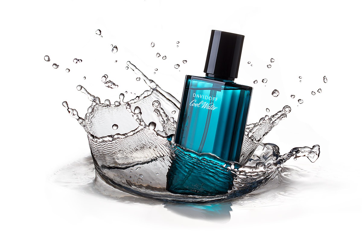 Flakon perfum Davidoff Cool Water zanurzony w wodzie, tworzący dynamiczny efekt rozprysku na białym tle, z precyzyjnym uchwyceniem kropli i refleksów świetlnych.
