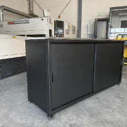 Czarna szafka warsztatowa na kółkach z przesuwnymi drzwiami, widoczna na tle maszyny CNC Mazak Super Turbo-X510 MKII w hali produkcyjnej.