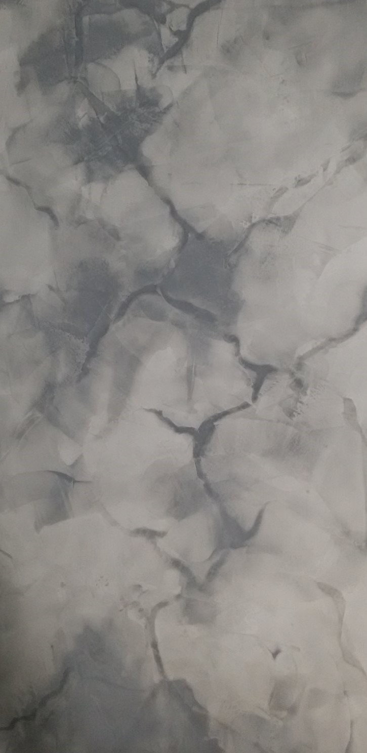 Ściana pokryta dekoracyjną, szarą strukturą imitującą marmur z wyraźnymi żyłami.