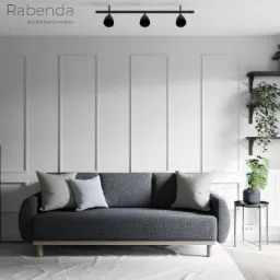 Szara sofa z poduszkami w minimalistycznym salonie z białymi ścianami, czarnymi półkami i lampami punktowymi.