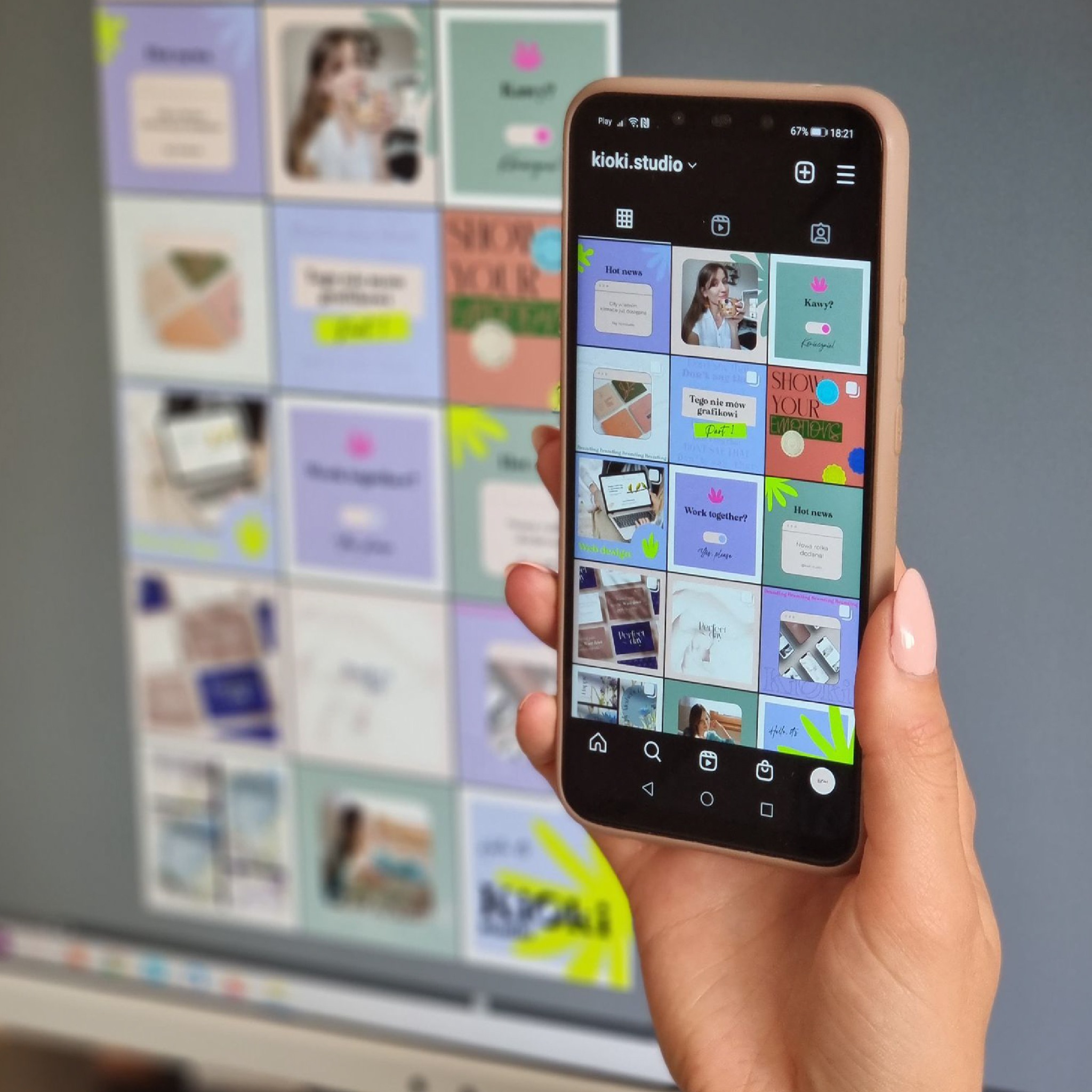 Ekran smartfona w dłoni prezentuje siatkę postów z Instagrama marki kioki.studio, z różnorodnymi grafikami i hasłami, takimi jak 'Hot news', 'Work together?' i 'Tego nie mów grafikowi', na tle...