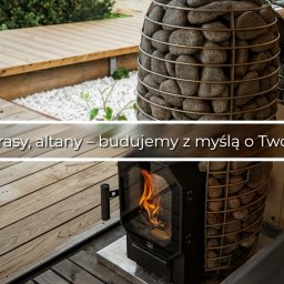 Tomasz Gajko - Sauna z piecem opalanym drewnem, obudowanym kamieniami, na drewnianym tarasie. Widoczne elementy wykończenia i logo firmy.