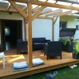 Taras z modrzewia europejskiego z zadaszeniem z poliwęglanu litego.