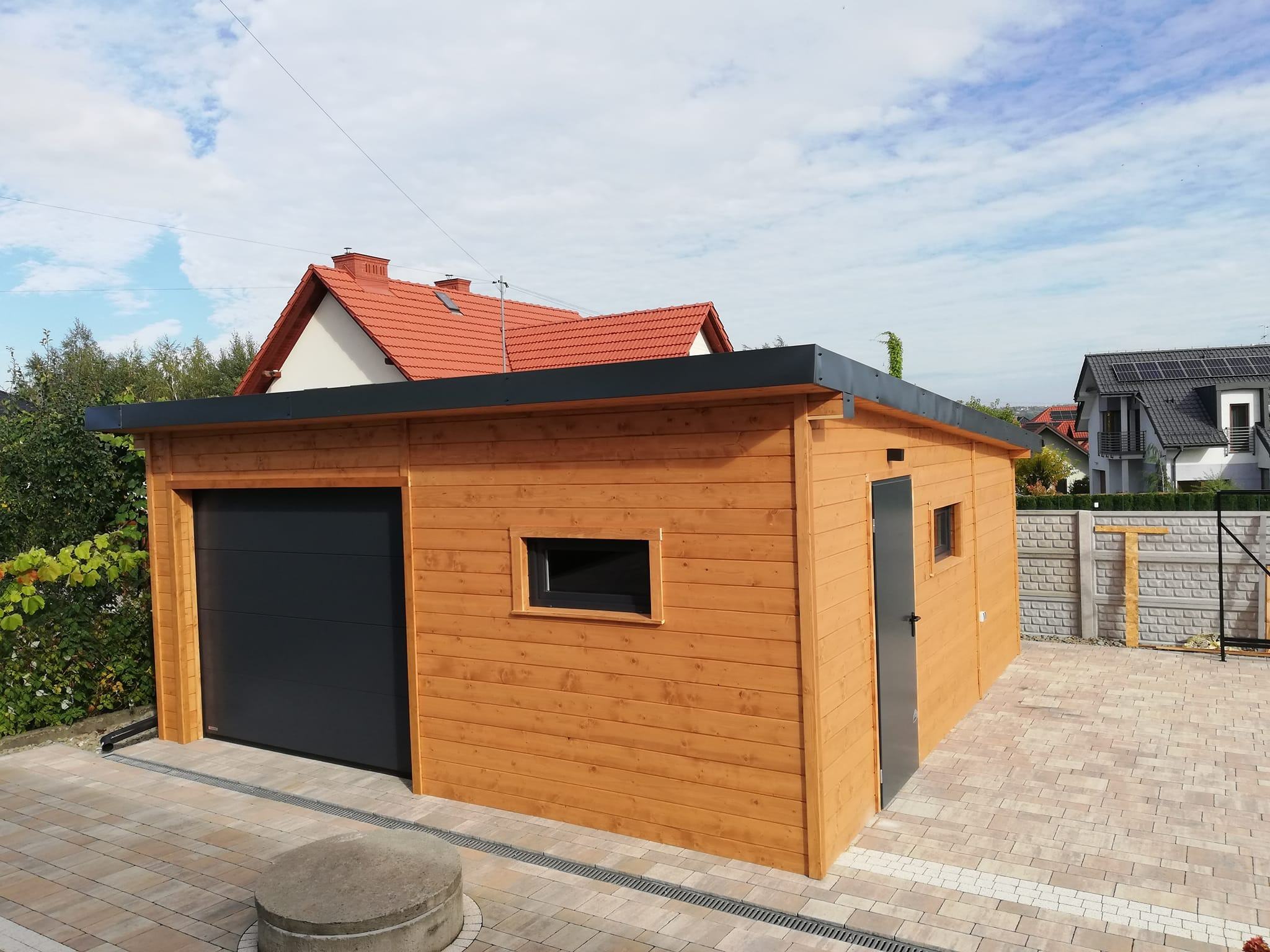 Garaż na samochód ze schowkiem na narzędzia ogrodowe.