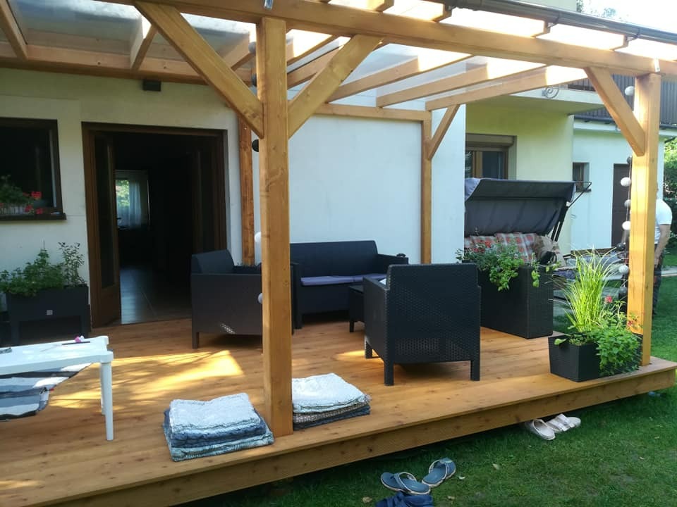 Taras z modrzewia europejskiego z zadaszeniem z poliwęglanu litego.