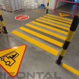 Horizontal Paweł Kasner - Oznakowanie poziome w hali magazynowej: żółte pasy przejścia dla pieszych, znaki ostrzegawcze z symbolem wózka widłowego, znaki STOP, słupki ochronne w czarno-żółte pasy.