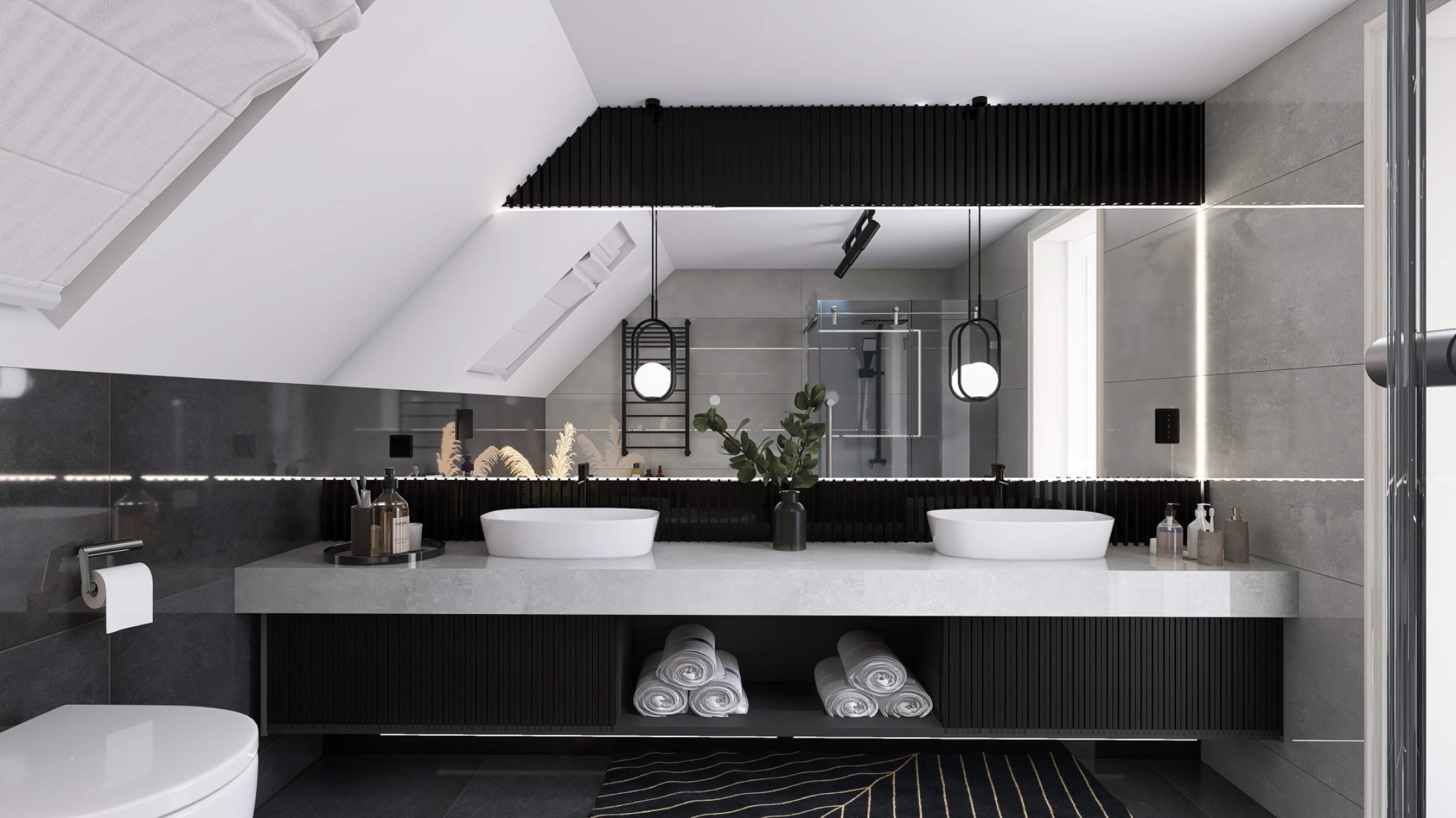 Nowoczesna łazienka na poddaszu z dwoma okrągłymi umywalkami, czarnymi akcentami, szarą płytką, dekoracyjnym oświetleniem LED i rośliną w wazonie na blacie.