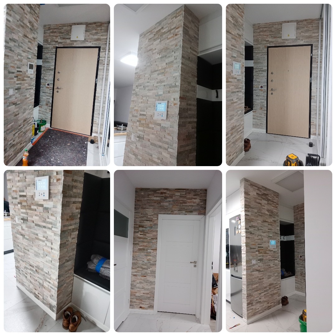 Korytarz po metamorfozie z dekoracyjną ścianą z kamienia naturalnego w odcieniach beżu i szarości, widoczny panel sterowania inteligentnego domu oraz wejście do mieszkania z nowymi drzwiami.