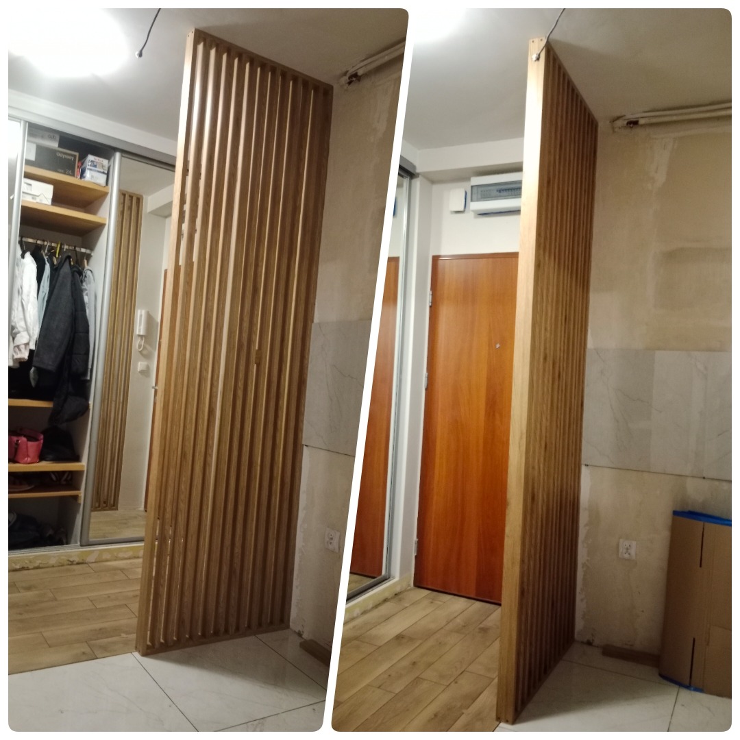 Drewniana ścianka działowa z pionowych listew zamontowana w korytarzu w Markach, widoczna wnęka szafy w tle po lewej stronie, drzwi wejściowe po prawej.